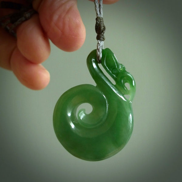 Hand carved medium sized Inanga jade manaia with koru pendant. Made for NZ Pacific by Ross Crump. We will ship this to you with an express courier service. This is a one-off piece and is collectable. A gorgeous pendant!