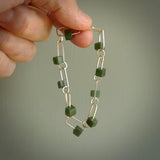 This bracelet is handmade from New Zealand Jade and sterling silver. It has a delicate cube of pounamu within each link of Sterling Silver chain and the Jade moves within each chain link.
