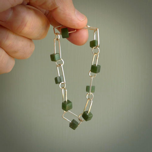 This bracelet is handmade from New Zealand Jade and sterling silver. It has a delicate cube of pounamu within each link of Sterling Silver chain and the Jade moves within each chain link.