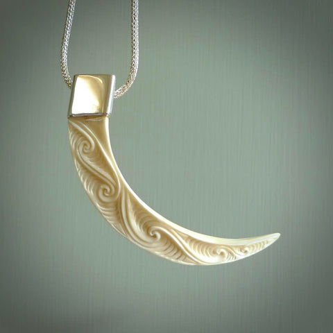 Hand carved, engraved Boars Tusk Pendant with a sterling silver cap. Hand made pendant carved from a boars tusk. Hand made unique jewellery for sale by NZ Pacific online.