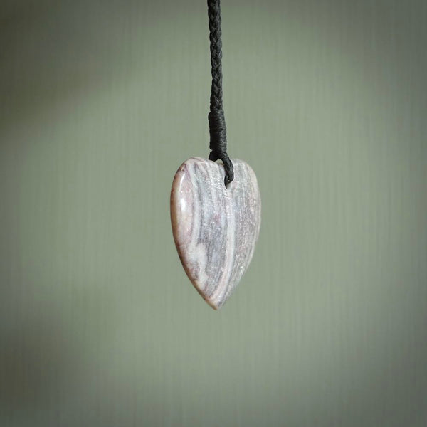 A hand carved heart pendant made from New Zealand Rhodonite Stone. This is a medium sized and visually striking piece, beautifully curved and sensuous. The perfect piece of jewellery for someone you love.