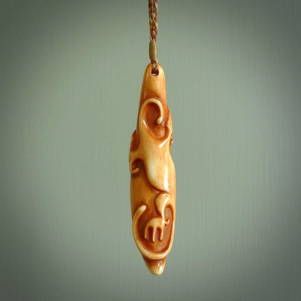 Bone carving of a lizard climbing. A three dimensional pendant carved in bone by Yuri Terenyi. One only contemporary gecko lizard carving for men and women. Provided with an adjustable cord.