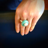 This is a handcrafted white siberian jade ring with turquoise and sterling silver. The colours are a bright aquamarine turquoise blue and white. This is a solid little work of art. We ship this worldwide for free and are happy to answer any questions that you may have about these or other products on our website.