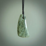 A hand carved curved contemporary drop pendant. This is a piece of genuine jade jewellery, hand carved by Raegan Bregmen. He has used rare New Zealand jade and has utilised his experience and carving skill to highlight the natural beauty of the stone. Delivered worldwide, postage is included in the price.