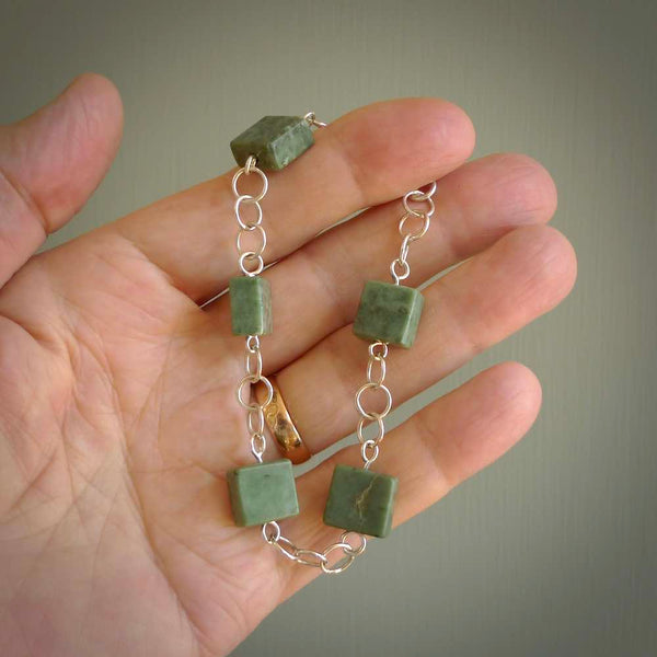 This bracelet is handmade from New Zealand Jade and sterling silver. It has five squared blocks of Jade in between a sterling silver chain, this is a fashionable bracelet for lovers of art to wear.