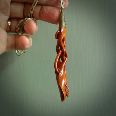 This pendant is carved from cow bone and stained with a homemade tea dye. It is a unique piece of wearable art that is sure to catch the eye. The shape is a complex twist form and has been beautifully hand carved by bone carver Yuri Terenyi.