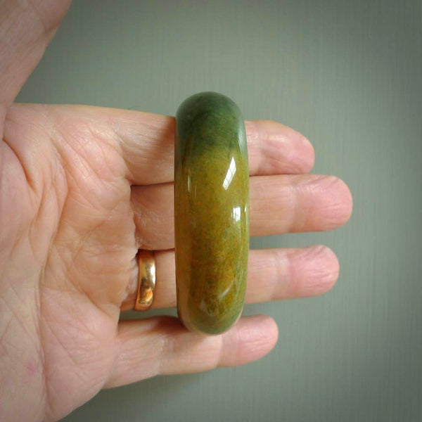 Hand carved jade bangle. Carved from green New Zealand jade. This is a solid jade bangle carved from a single piece of jade. It is polished to a soft shine. the jade is otherwise untreated and completely natural.
