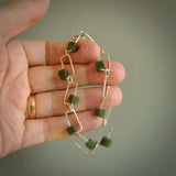 This bracelet is handmade from New Zealand Jade and sterling silver. It has a delicate cube of pounamu within each link of Sterling Silver chain and the Jade moves within each chain link.