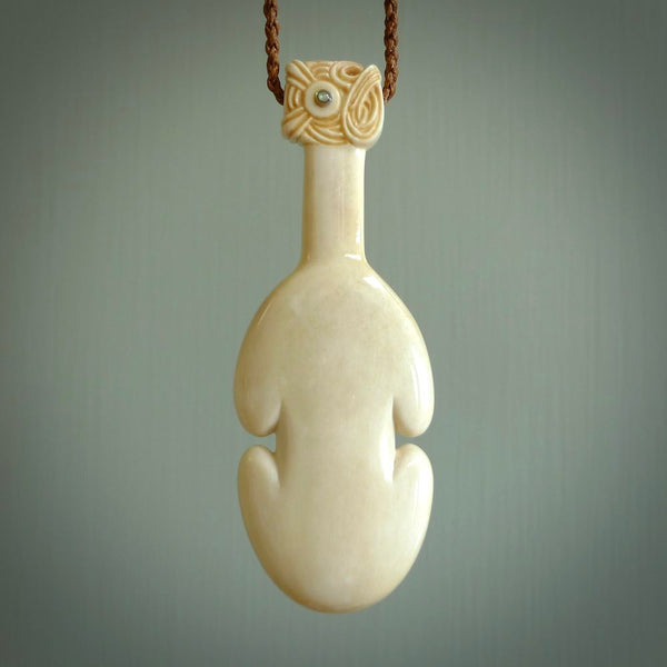 Hand carved engraved bone patu necklace hand made here in New Zealand. One only artistic patu pendant with hand plaited dark brown adjustable cord. Shipped to you with  Express Courier. Stand out patu pendant for men and women. Bone patu with Paua shell insert eyes.