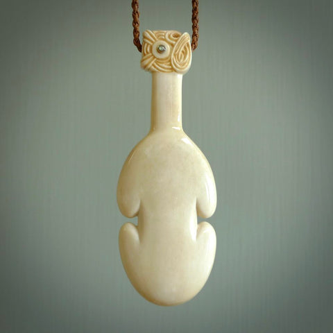 Hand carved engraved bone patu necklace hand made here in New Zealand. One only artistic patu pendant with hand plaited dark brown adjustable cord. Shipped to you with  Express Courier. Stand out patu pendant for men and women. Bone patu with Paua shell insert eyes.