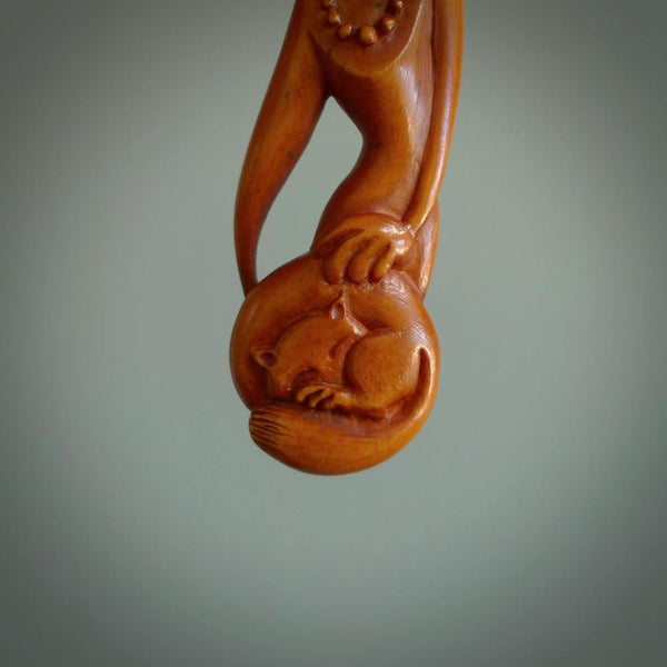 Hand carved stained bone female pendant in a repose shape with her cat. Made from natural bone. Bone jewellery from the Pacific for sale online. Female pendant for men and women.
