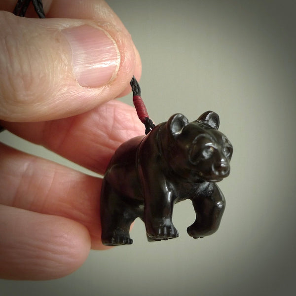 This picture shows a pendant that we designed in black jade. It is a little black bear that has a walking stance and is carved in detail. A really attractive and eye-catching piece of handmade jewellery. The cord is hand plaited braid in black and pale honey and the length can be adjusted.