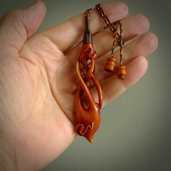 This necklace is carved from cow bone and stained with a homemade tea dye. It is a unique piece of wearable art that is sure to catch the eye. The shape is a complex twist form and has been beautifully hand carved by bone carver Yuri Terenyi.