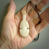 Hand carved engraved bone patu necklace hand made here in New Zealand. One only artistic patu pendant with hand plaited dark brown adjustable cord. Shipped to you with Express Courier. Stand out patu pendant for men and women. Bone patu with Paua shell insert eyes.