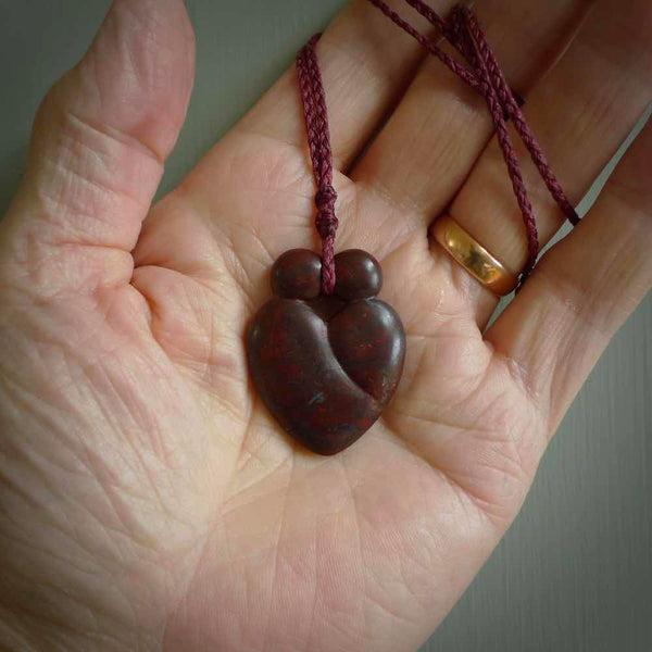 This is a handcarved love heart pendant made from a gorgeous and striking piece of red jasper stone. This is a superbly carved and very unique piece if custom jewellery. For sale online from NZ Pacific. Two sizes available; Medium and Large.