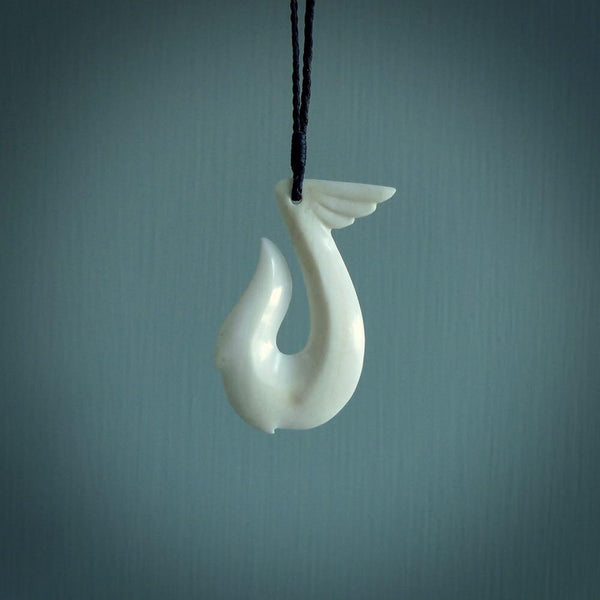 Hand carved bone hook pendant. This piece is carved with a winged decoration on the upper part. We've named it 'Avenger' after the Goddess Nike. Shipping is free worldwide.