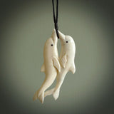 Hand carved double dolphin pendant. Carved for NZ Pacific by Fumio Noguchi in deer antler. This is a beautiful piece of jewellery that is carved with intricate detail and clearly shows a beautiful pair of cheerful dolphins. We ship this free worldwide.