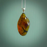This pendant is handcrafted from rare Burmese amber. We supply these with a sterling silver chain. It is a graceful and very interesting piece that will attract admiration and comment.