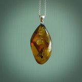This pendant is handcrafted from rare Burmese amber. We supply these with a sterling silver chain. It is a graceful and very interesting piece that will attract admiration and comment.