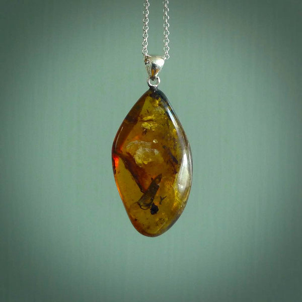 This pendant is handcrafted from rare Burmese amber. We supply these with a sterling silver chain. It is a graceful and very interesting piece that will attract admiration and comment.