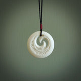 A hand carved and engraved koru pendant carved for us by Yuri Terenyi. These are beautiful little pieces are emblematic of the well known and loved Koru design.