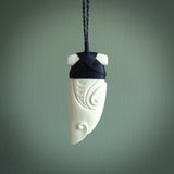 Hand carved bone rei puta design pendant. This is a lovely traditional piece that we have bound with a hand plaited Pale honey and burgundy coloured adjustable cord. A beautiful pendant with a south pacific design.