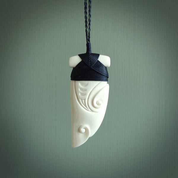 Hand carved bone rei puta design pendant. This is a lovely traditional piece that we have bound with a hand plaited Pale honey and burgundy coloured adjustable cord. A beautiful pendant with a south pacific design.