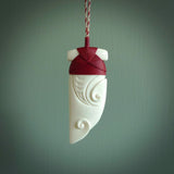 Hand carved bone rei puta design pendant. This is a lovely traditional piece that we have bound with a hand plaited Pale honey and burgundy coloured adjustable cord. A beautiful pendant with a south pacific design.