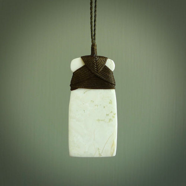 This pendant is a lovely toki carved from white onyx stone. It is a traditional shape and is traditionally bound but carved from a striking white stone. A beautiful piece of handmade jewellery from NZ Pacific.