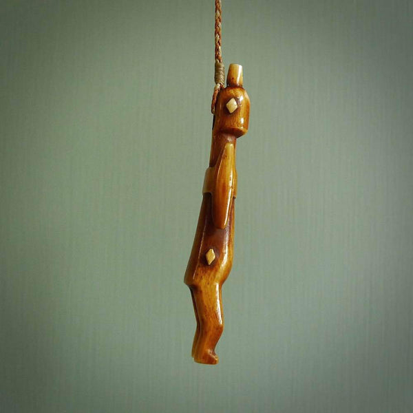 POKERFACE - a traditional Gambier Island figurine, carved as a pendant. This piece was hand carved for us by Yuri Terenyi. This is a work of art and is a collectable piece of traditional bone carving. It can be worn as a special piece of jewellery or displayed. This is art made to wear at its finest.