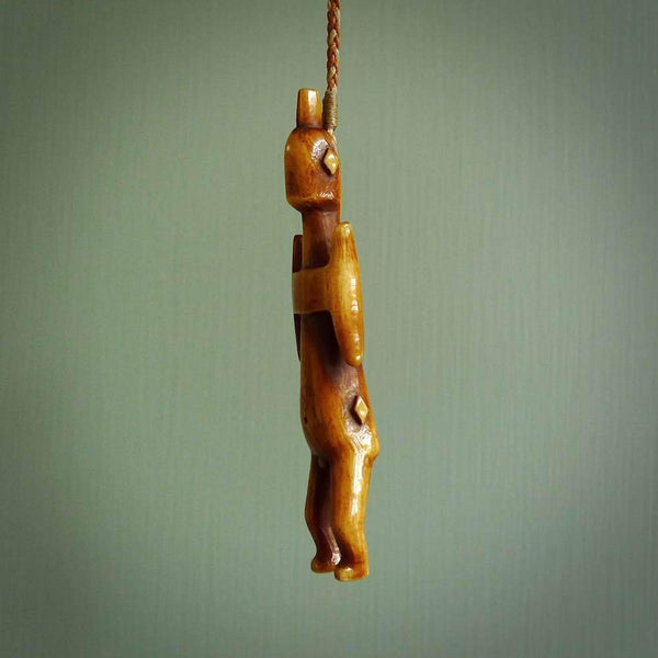 POKERFACE - a traditional Gambier Island figurine, carved as a pendant. This piece was hand carved for us by Yuri Terenyi. This is a work of art and is a collectable piece of traditional bone carving. It can be worn as a special piece of jewellery or displayed. This is art made to wear at its finest.