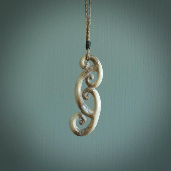 This is a wonderful, gently curved piece with a multiple koru design. We've carved this from deer antler and bind it on hand-plaited cords of various colours. Order yours now on NZ Pacific at www.nzpacific.com