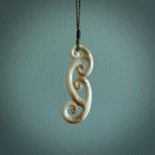 This is a wonderful, gently curved piece with a multiple koru design. We've carved this from deer antler and bind it on hand-plaited cords of various colours. Order yours now on NZ Pacific at www.nzpacific.com