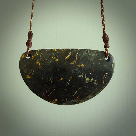 A hand carved plate pendant made from New Zealand peridotite stone. This is a larger piece and the stone is a wonderful mottled brown grey. A stunning piece of hand made jewellery by NZ Pacific.