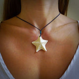 Hand carved bone starfish pendant shown worn. Ocean themed pendants carved by NZ Pacific. Moana pendants for sale online.