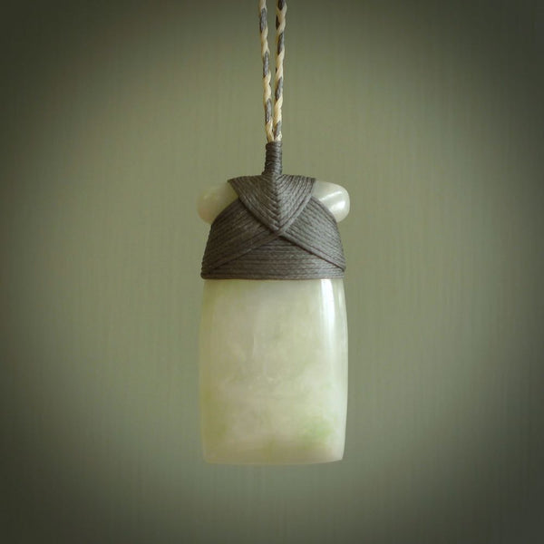 This picture shows a hand carved jadeite toki. The stone is a wonderful and very subtle pale whitish grey green. It is polished to a high shine. The cords are hand plaited and adjustable. We ship these free worldwide.