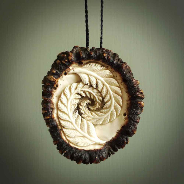 A hand carved double fern leaf pendant made from a piece of deer antler crown. This is a work of art carved by Fumio Noguchi who is renowned for his skill in bone carving. The moa is an extinct, flightless native New Zealand bird. This is a great piece representing this very rare bird.