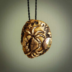 A hand carved crab with starfish pendant carved from a piece of deer antler crown. This is a work of art carved by Fumio Noguchi who is renowned for his skill in bone carving. This is a great piece for ocean lovers. Unique crab with sea star pendant, collectors work of art.