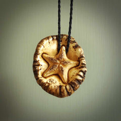 A hand carved crab with starfish pendant carved from a piece of deer antler crown. This is a work of art carved by Fumio Noguchi who is renowned for his skill in bone carving. This is a great piece for ocean lovers. Unique crab with sea star pendant, collectors work of art.
