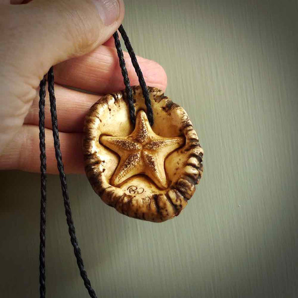 A hand carved crab with starfish pendant carved from a piece of deer antler crown. This is a work of art carved by Fumio Noguchi who is renowned for his skill in bone carving. This is a great piece for ocean lovers. Unique crab with sea star pendant, collectors work of art.