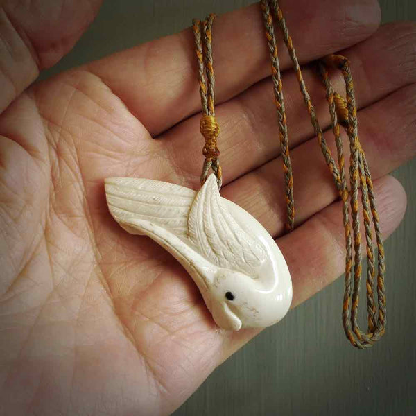 Hand carved huia bird made from cow&nbsp;bone pendant. Carved for NZ Pacific by Fumio Noguchi. This is a contemporary piece of jewellery that is carved with intricate detail and clearly shows a beautiful bird. We ship this free worldwide.