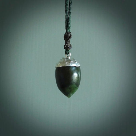 This picture shows a little jade acorn pendant. The cap is sterling silver and is embossed with some decorative markings which give the silver cap some detail and character.