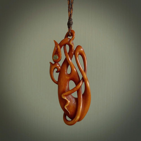 A one off beautiful piece of carved art. We have called this Enigma, it was hand carved for us by Yuri Terenyi and is a manaia with twist design pendant. This is a wonderful ethnic bone pendant designed to be worn. It has been stained by a homemade tea dye in a bright gingery brown colour and we have hand plaited an adjustable cord in khaki, ice white and ginger nut colours.